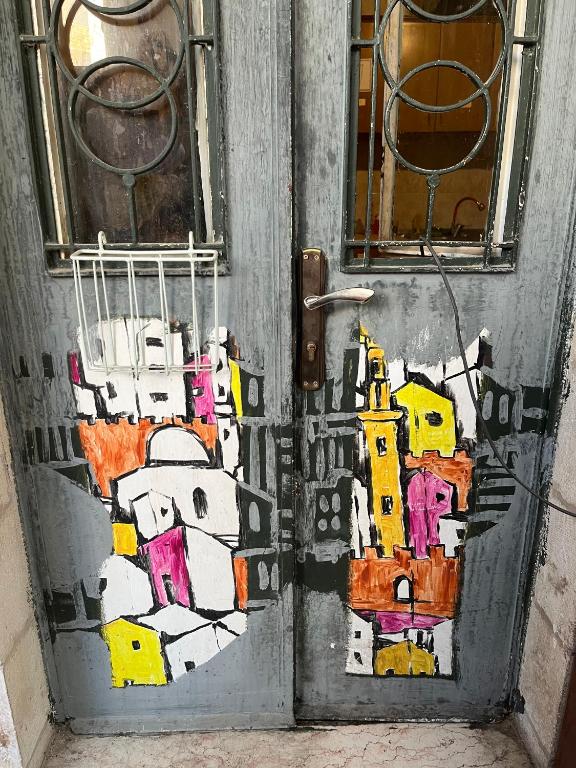 a door with a painting on it at bayt alrahaal in Amman