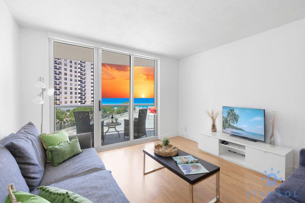 a living room with a couch and a tv at Tides beautiful ocean view condo-promotions in Hollywood