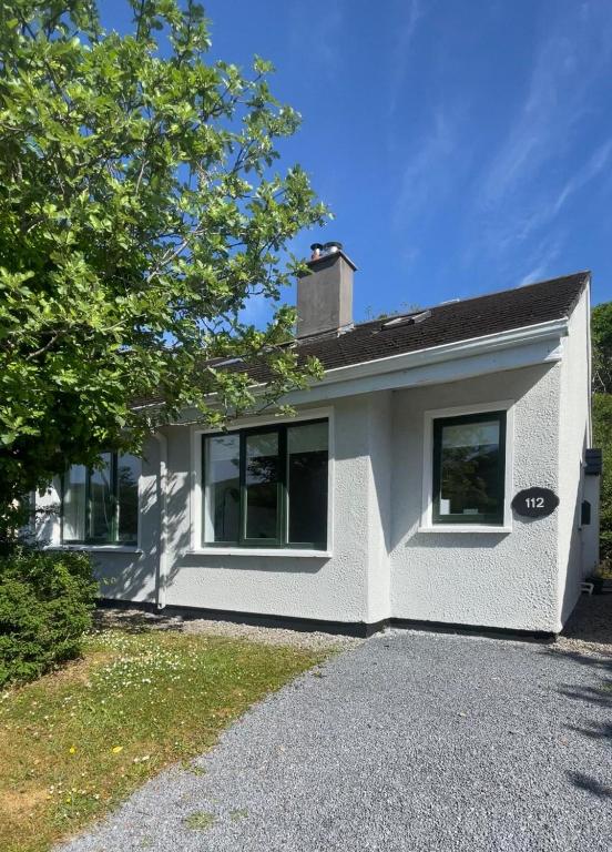 a white house with a driveway in front of it at 112 Clifden Glen in Clifden