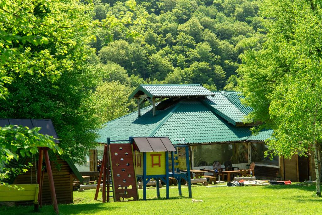a house with a play structure in the yard at Grand Tara Rafting Resort in Foča