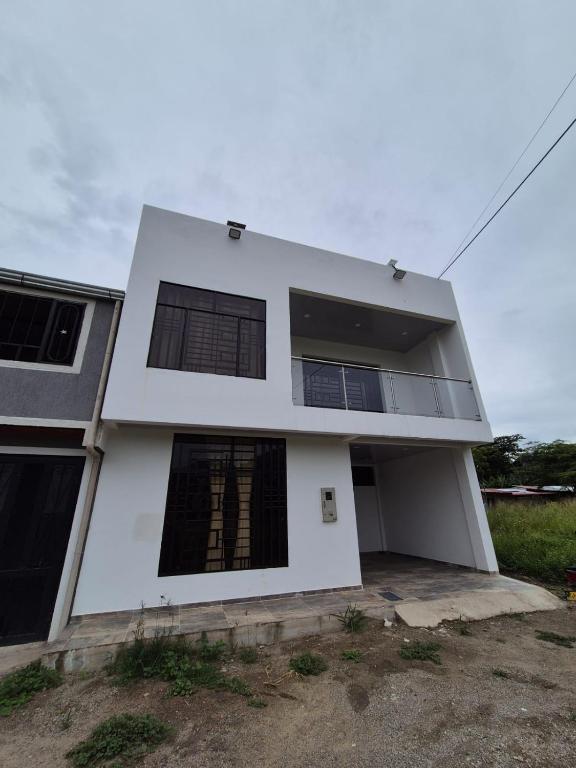 a white house with black windows at Casa de Char Girardot, Nariño Cundinamarca in Nariño