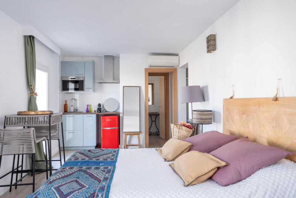 a bedroom with a large bed and a kitchen at Formentera Especial in La Savina