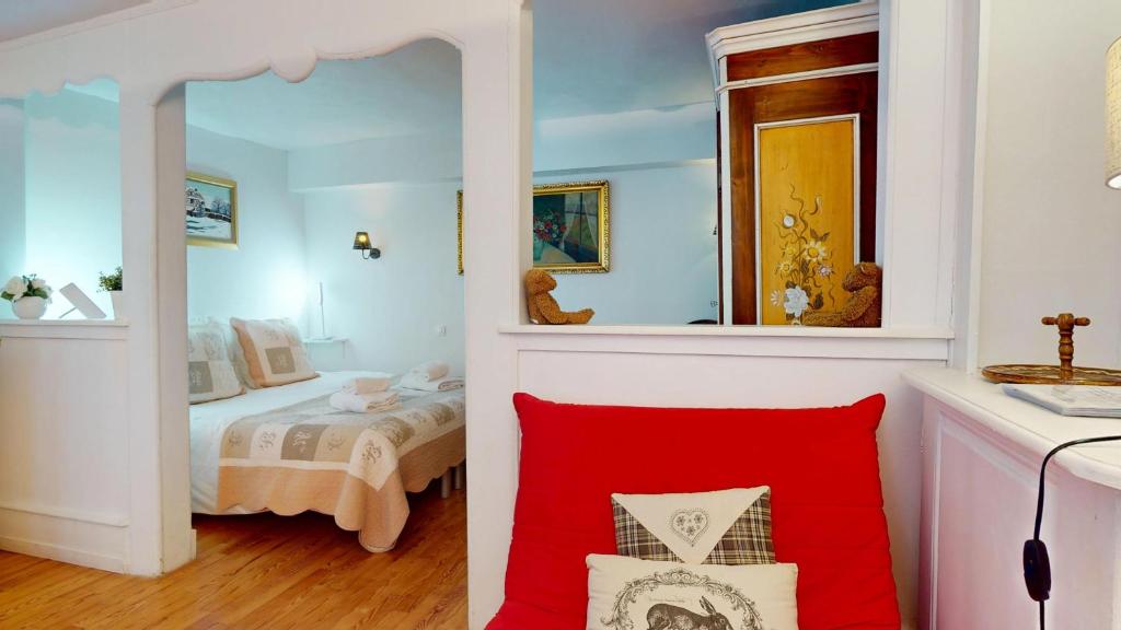 une petite chambre avec un lit et un miroir dans l'établissement Maison Le Clos Bartholdi, à Colmar