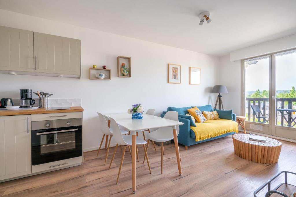 une cuisine et un salon avec une table et un canapé dans l'établissement Bleu d'Ornano - proche de la plage, à Blonville-sur-Mer