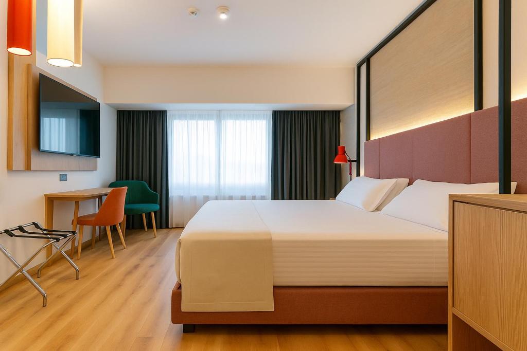 una camera d'albergo con un letto grande e una scrivania di Hotel Poseidon a Torre del Greco