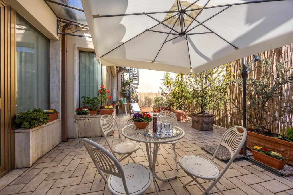 a patio with a table and chairs and an umbrella at CasAdòro in Arezzo
