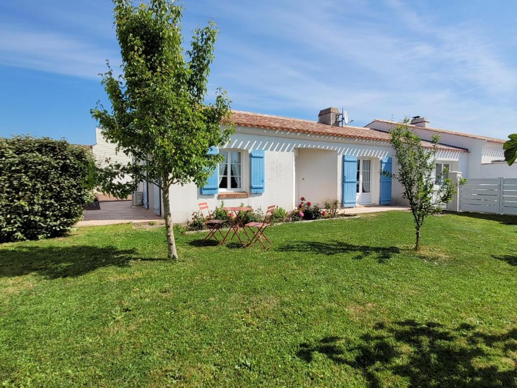 une maison avec deux arbres dans une cour dans l'établissement L'abri côtier, à Brem-sur-Mer