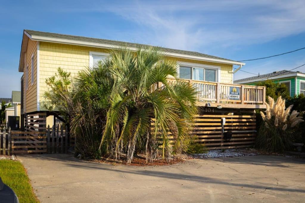 a house with a palm tree in front of it at Near Beach Dining & Shops Private Hot Tub in Kill Devil Hills