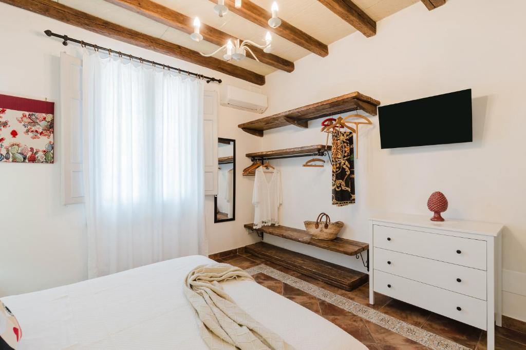 une chambre avec un lit et une télévision au mur dans l'établissement Le Giarre - Villa Con Piscina, à Marausa