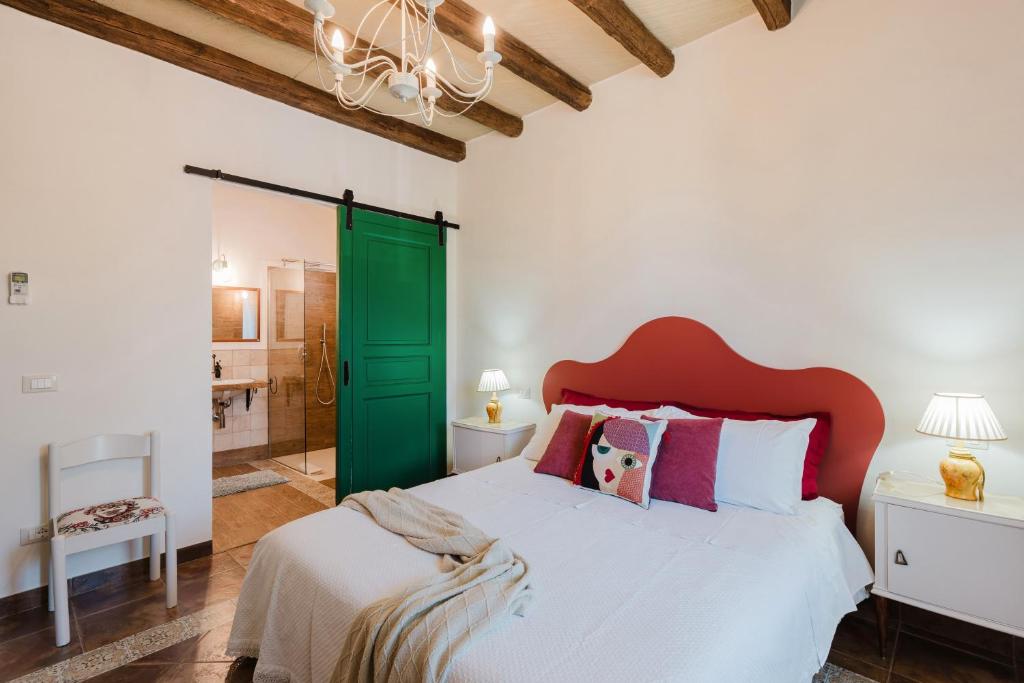 - une chambre avec un grand lit et une porte verte dans l'établissement Le Giarre - Villa Con Piscina, à Marausa