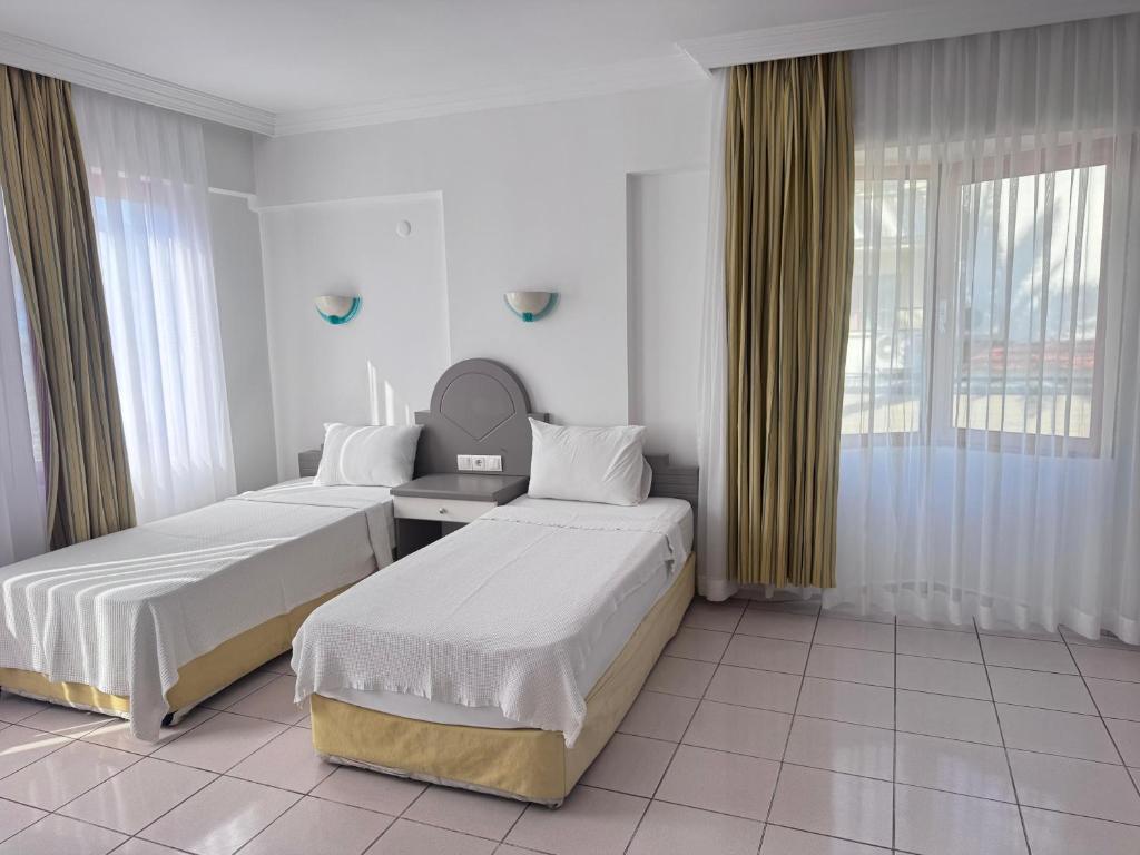 a hotel room with two beds and a mirror at Club Kocer Apartments in Marmaris