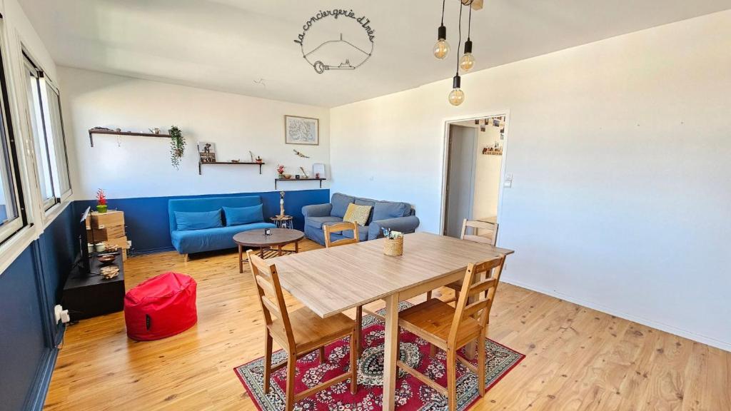 un salon avec une table et un canapé bleu dans l'établissement Le André #Parking#Confort, à Clermont-Ferrand