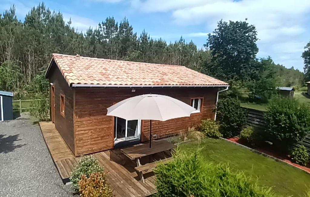 une petite cabine avec un parasol dans une cour dans l'établissement Océan House Le Porge, à Le Porge