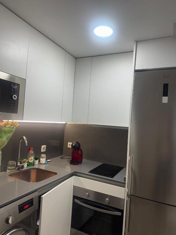 a small kitchen with a sink and a refrigerator at Euro 27 in Madrid