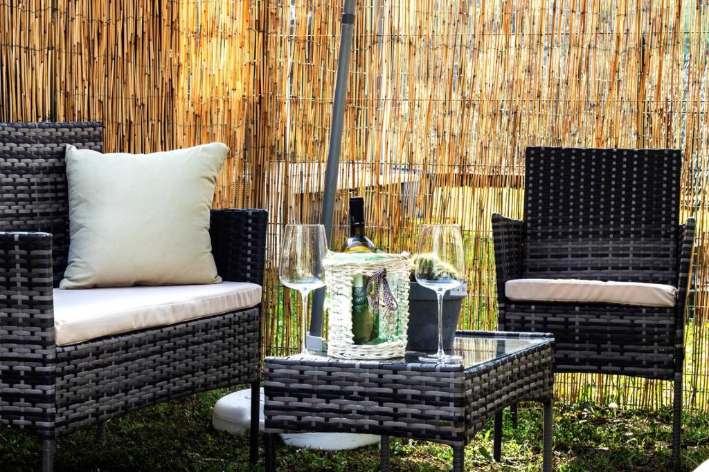 LakeComo- Voltahub في كومو: فناء مع كرسيين وطاولة مع كؤوس للنبيذ