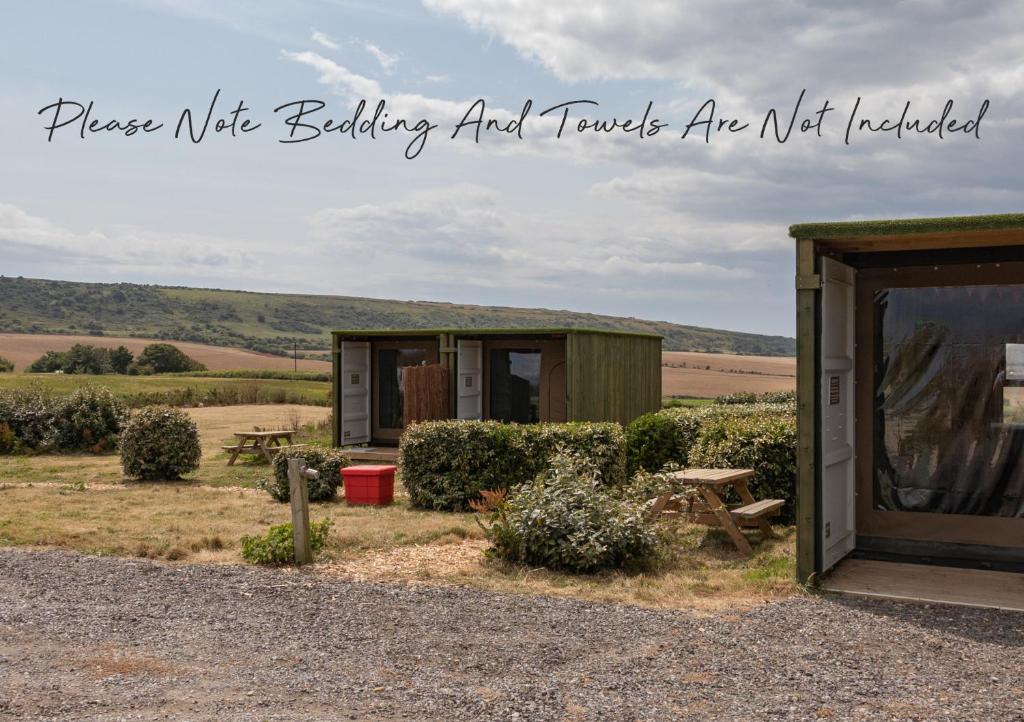 a small shed with a table and a picnic table at 8 Dragon Fly Den, Camp Tapnell in Yarmouth