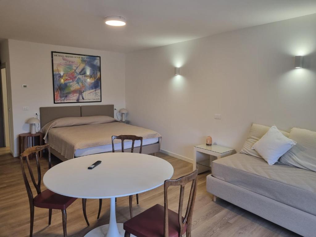 a room with two beds and a table and a couch at 2bebike in Manerba del Garda