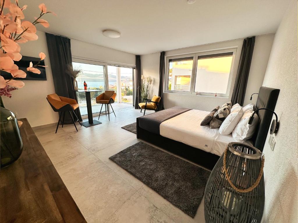 una camera da letto con un letto e un tavolo con sedie di Romantic coastal apartment with sea views a Komarna