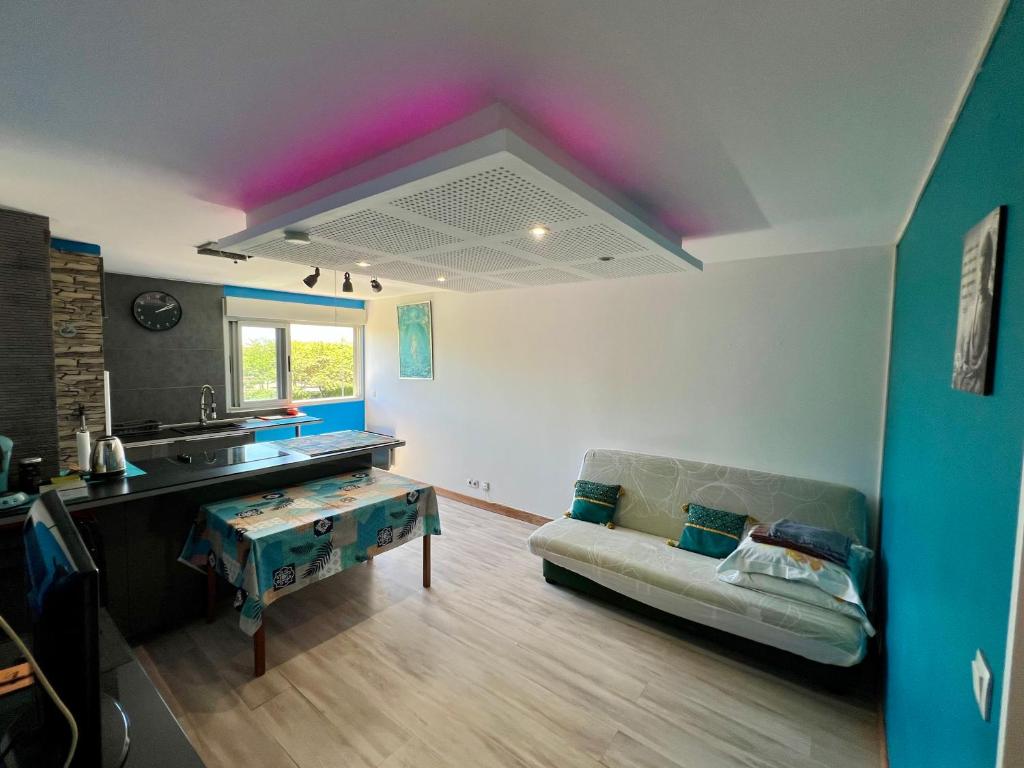 - un salon avec un canapé et un lavabo dans l'établissement C19 Jules Verne, au Cap d'Agde