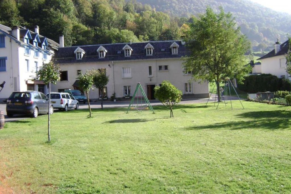 une grande cour avec des arbres devant un bâtiment dans l'établissement Maison Cazaux - Appt 1, à Esterre