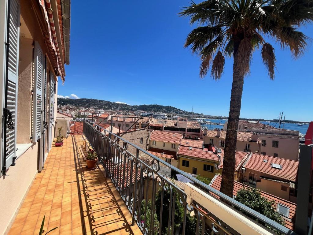 un balcon avec un palmier et une ville dans l'établissement Belle-epoque apartment ,3bedrooms with sea view, à Cannes