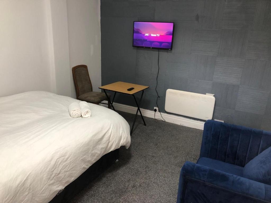 Un dormitorio con una cama y un televisor en una pared. en Marina Regency, en Moffat