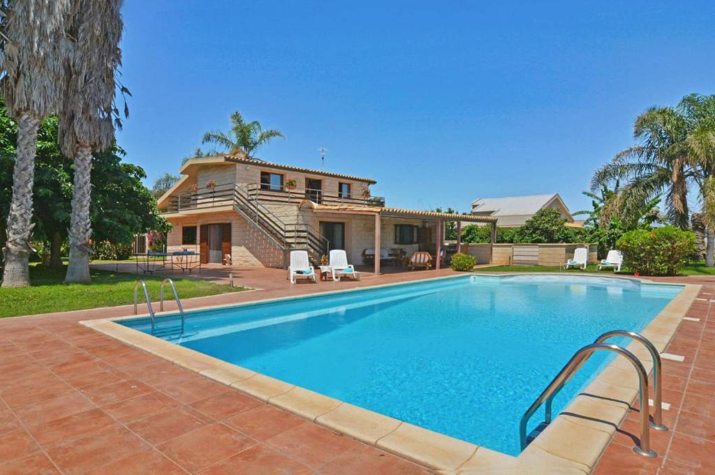 une piscine devant une maison dans l'établissement Villa Garofani by Villa Plus, à Punta Secca