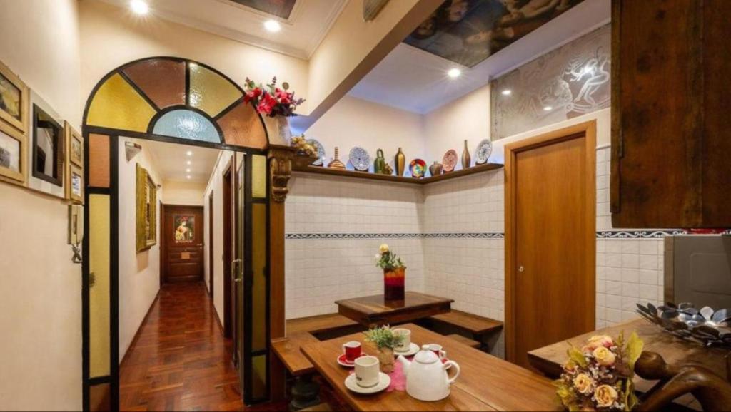 a living room with a table and a hallway at Sancta Scala in Rome