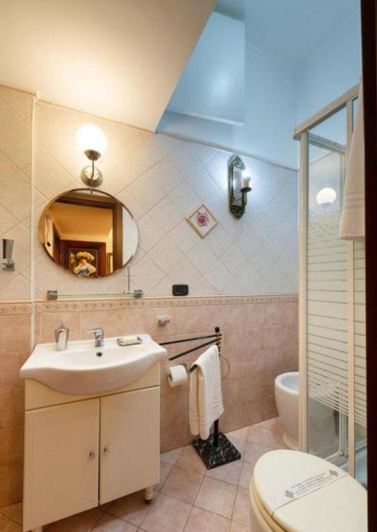 a bathroom with a sink and a toilet and a mirror at Sancta Scala in Rome
