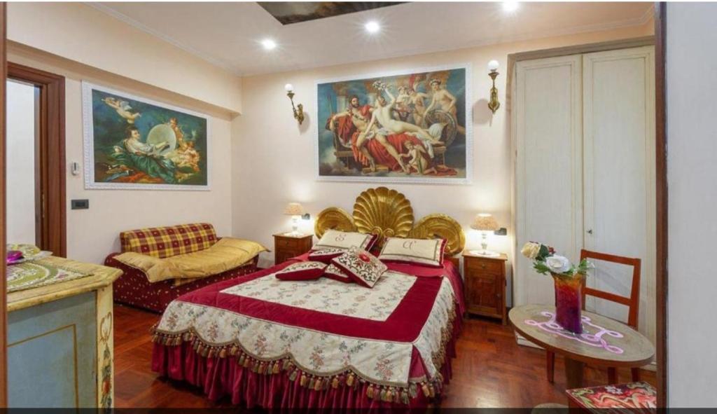 a bedroom with a bed and a couch and paintings at Sancta Scala in Rome