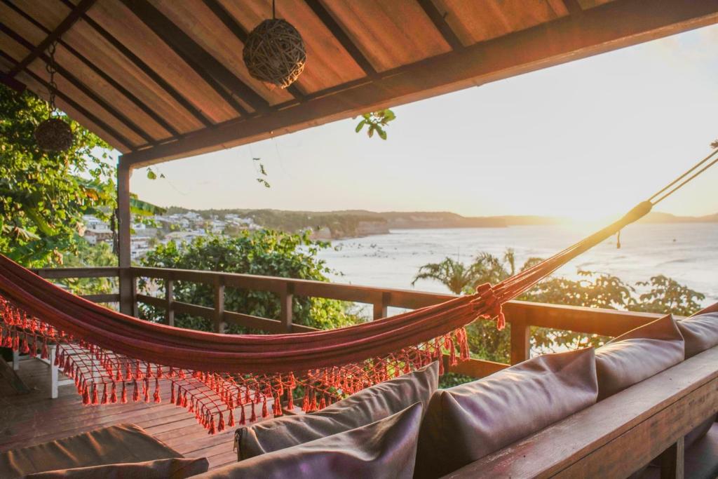a hammock on a deck with a view of the ocean at Escape byBeck in Pipa