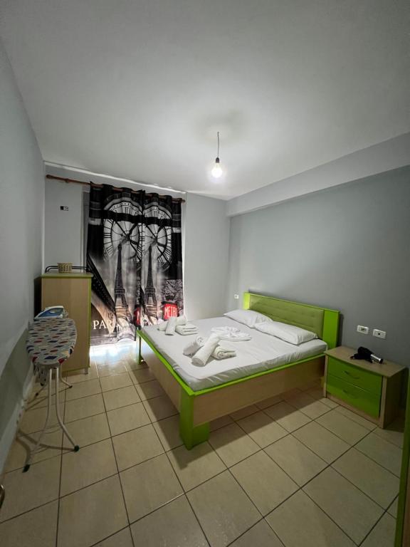 a bedroom with a green bed and a fireplace at Orikum RelaxHouse in Orikum