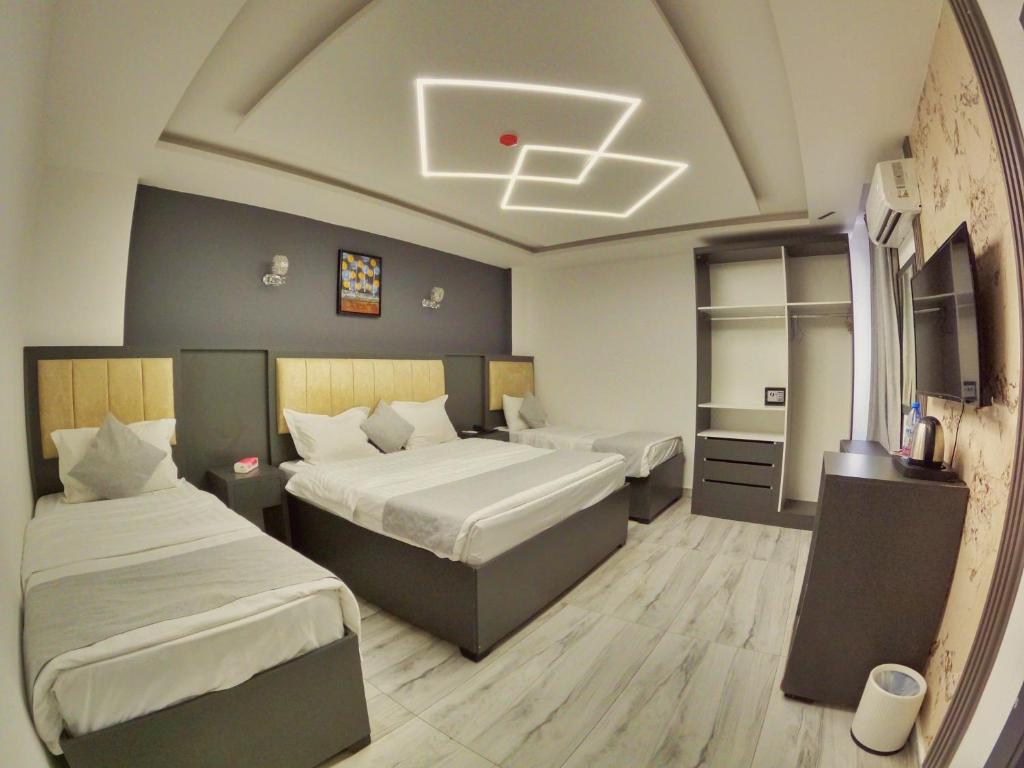 una camera d'albergo con due letti e una tv di Holiday Season Hotel ad Aqaba