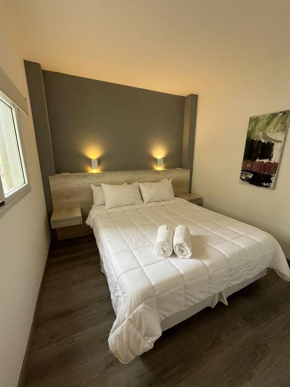 a bedroom with a large white bed with towels on it at Hotel República Junior Suite in Villa María