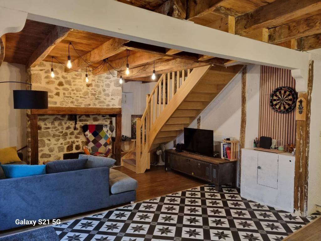 - un salon avec un canapé bleu et un escalier dans l'établissement Petit nid, à Laroquebrou