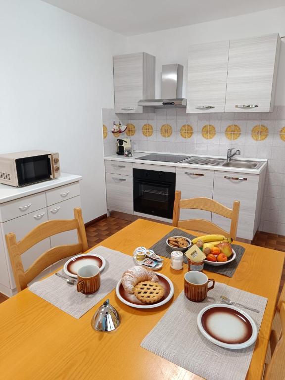 a kitchen with a wooden table with food on it at Appartamento Pizzo Cassandra in Chiesa in Valmalenco