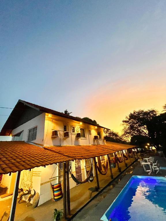 a house with a swimming pool in front of it at Pousada Marajó For You in Soure