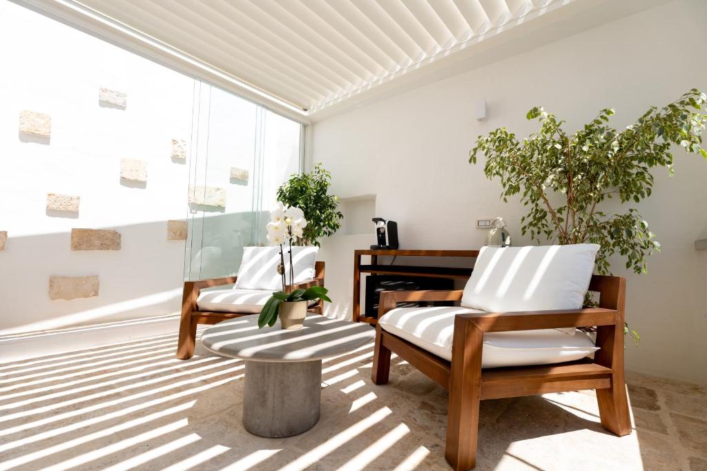 a living room with two chairs and a piano at Acquasale - Antica Dimora Cialledda in Polignano a Mare