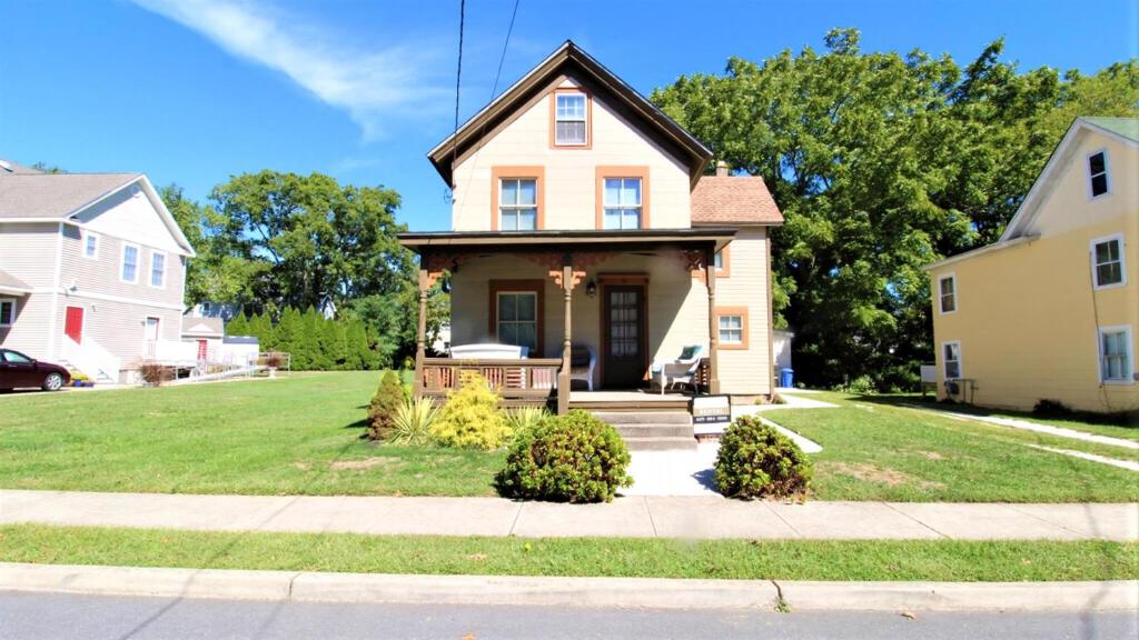 a house on a street with a grass yard at 111 Leaming Ave in West Cape May