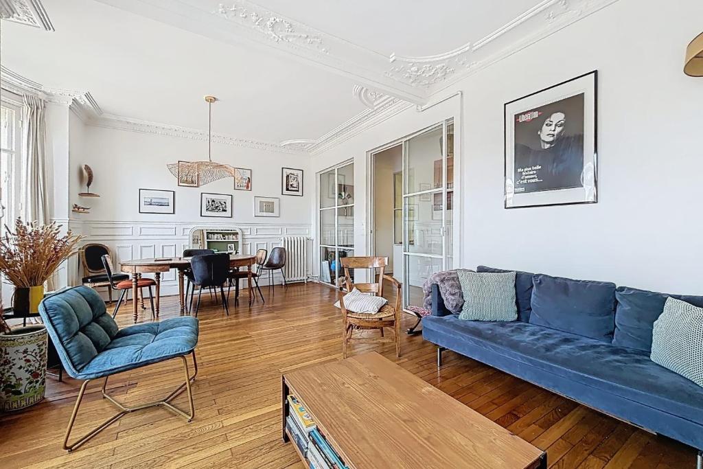 un salon avec un canapé bleu et une table dans l'établissement Large family duplex near Parc Monceau, à Paris