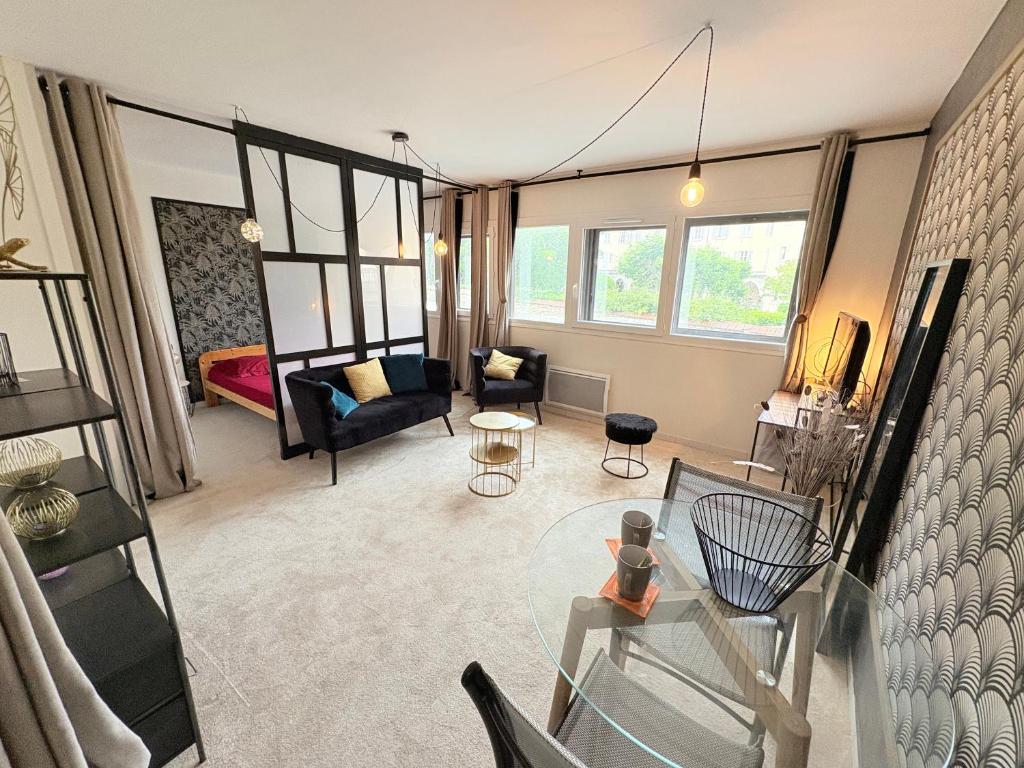 a living room with a glass table and a couch at Biarritz Centre Jardin Public et Gare du Midi in Biarritz