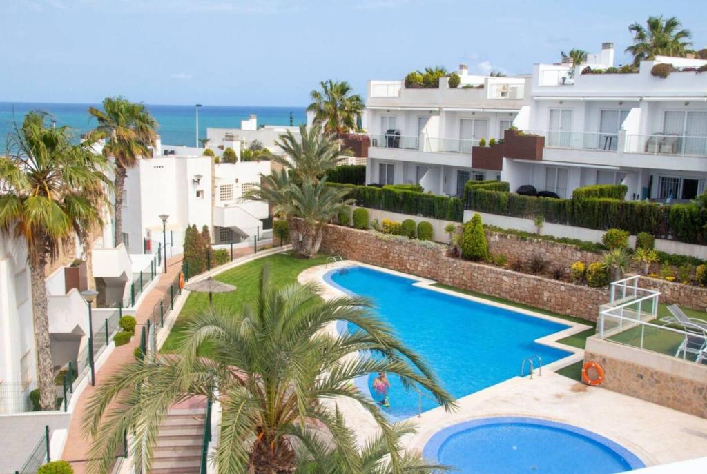 an aerial view of a resort with a swimming pool and palm trees at Nova Beach Penthouse in Gran Alacant