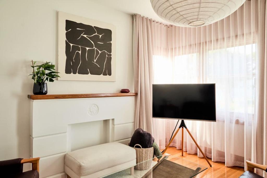 un salon avec un canapé et une télévision dans l'établissement Mid-Century Modern Retreat, à Kings Park