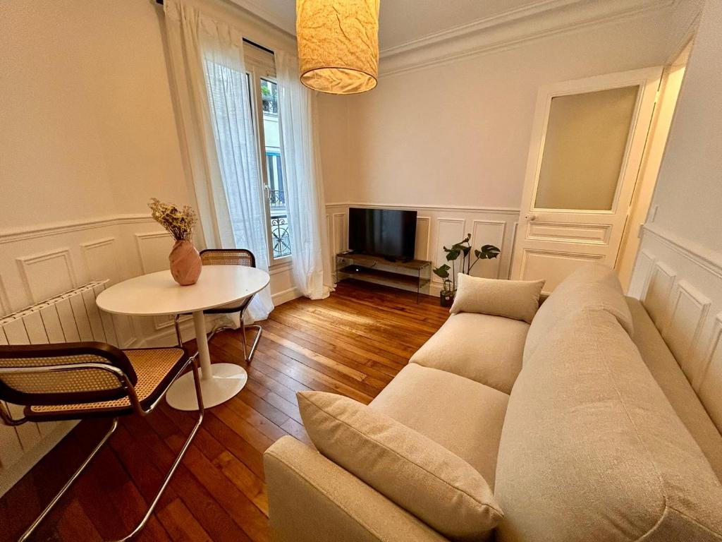 un salon avec un canapé et une table dans l'établissement Parisian nest, à Paris