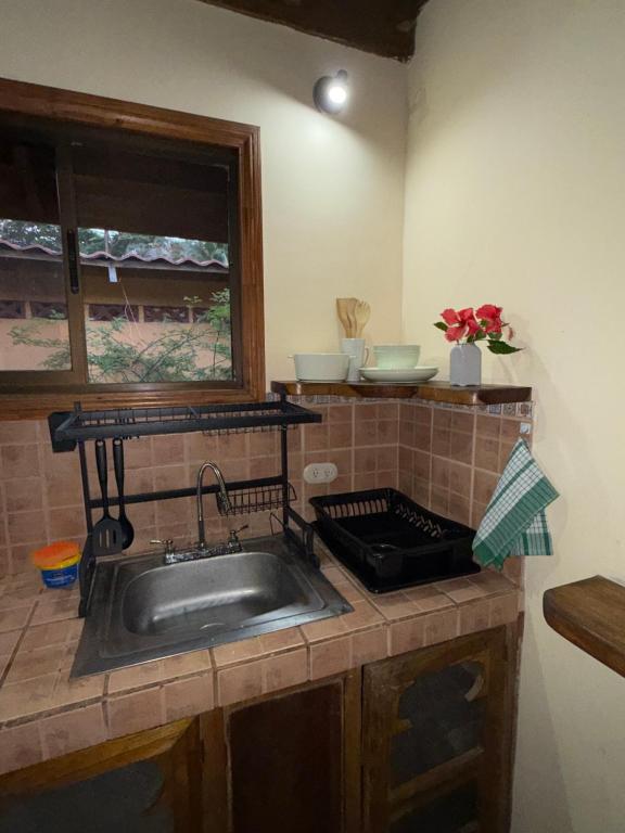 a kitchen counter with a sink and a window at Pool House with free bikes! in Puerto Viejo