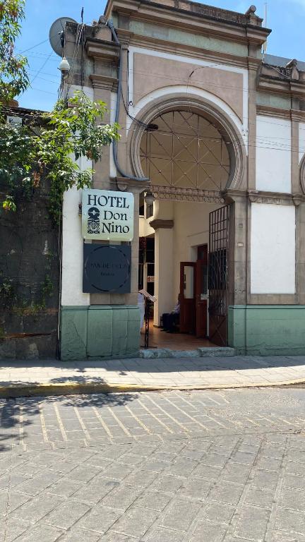 a building with a sign for a hotel next to a street at Hotel Don Nino in Oaxaca City