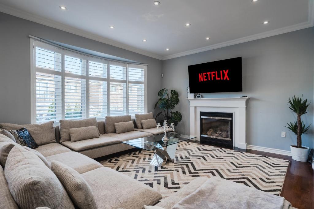 a living room with a couch and a fireplace at Cozy 5 Bedroom House near Toronto Airport in Mississauga