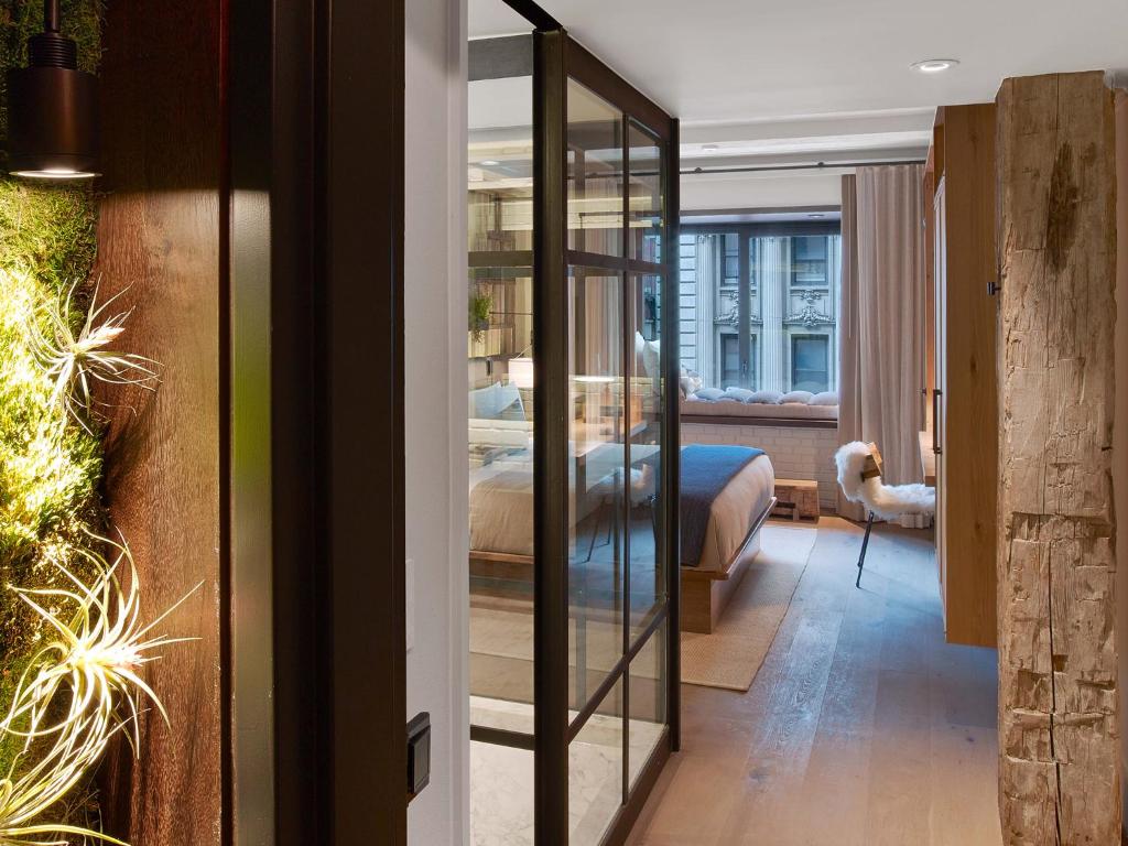 a room with a bedroom with a bed and a mirror at 1 Hotel Central Park in New York