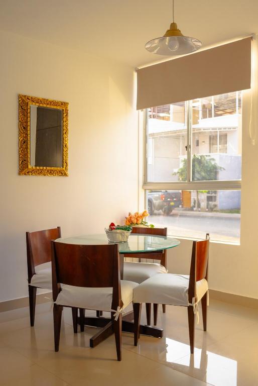 伊察Don Checho's House的一间有桌子、椅子和窗户的餐厅