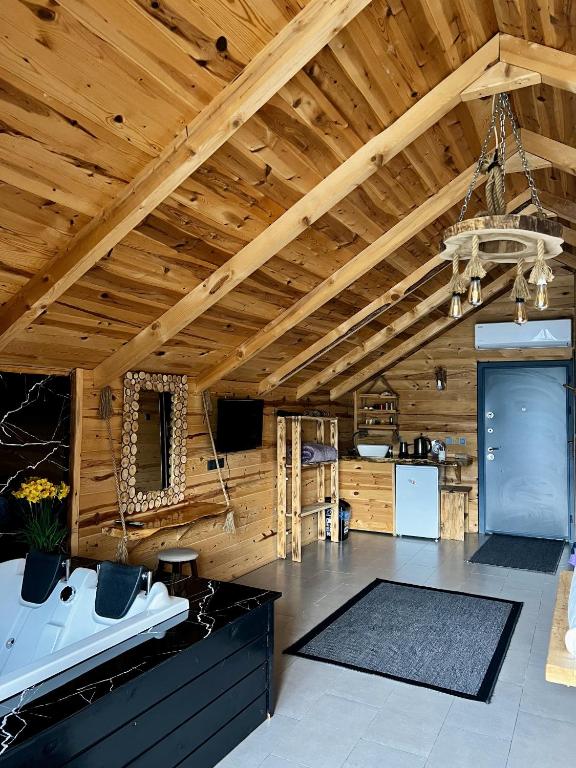 a large room with a wooden ceiling and a kitchen at Masal Suit in Çamlıhemşin